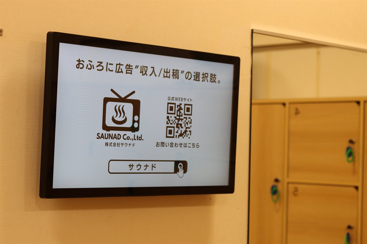 脱衣所の壁面に設置したふろビジョンのデジタルサイネージ